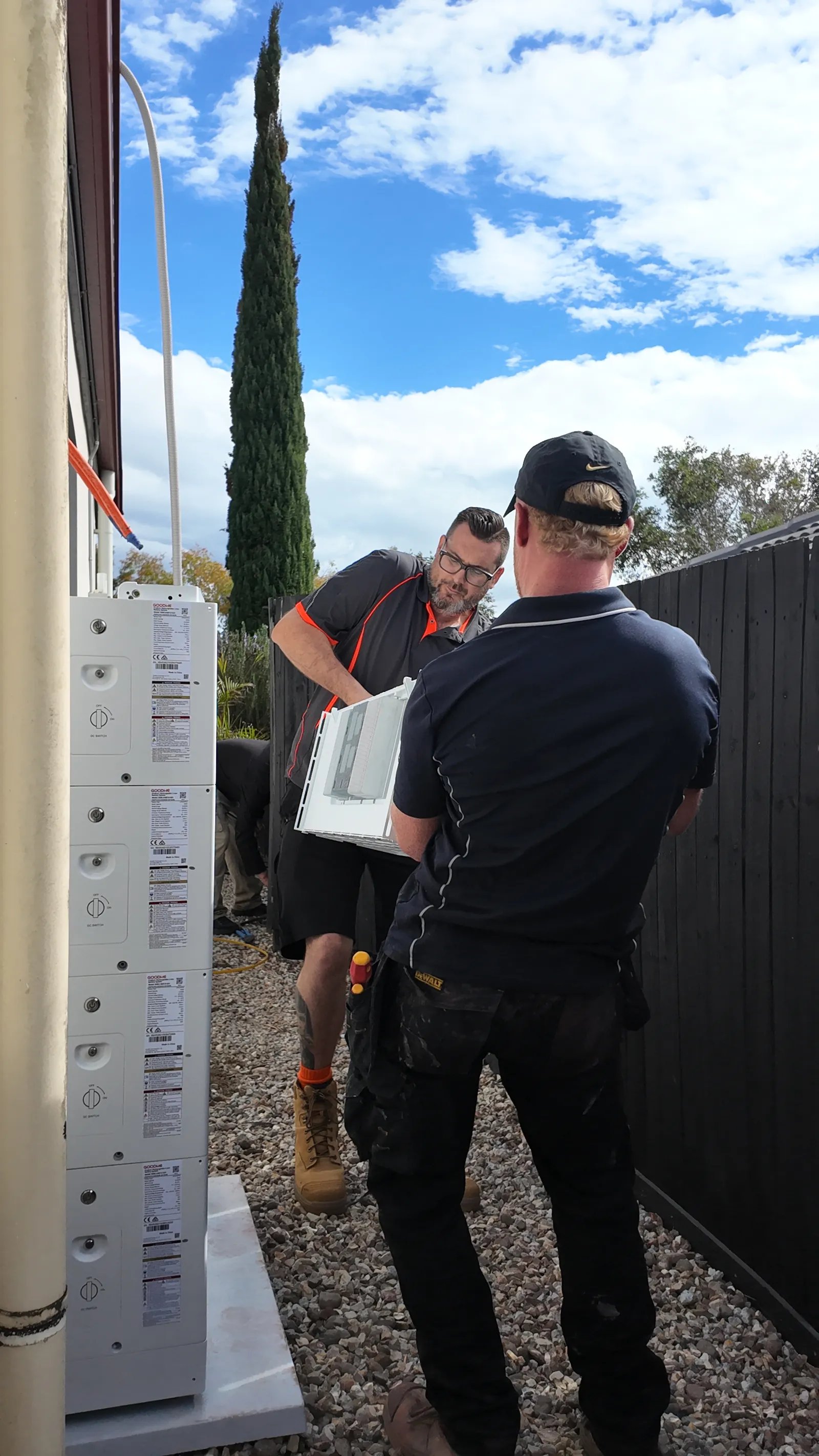 Worth Solar Group crew handing off a battery module on site